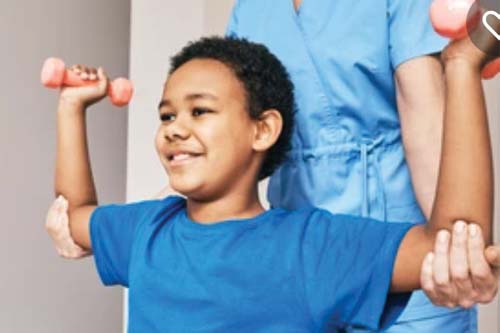 Boy lifting small weights with assistance