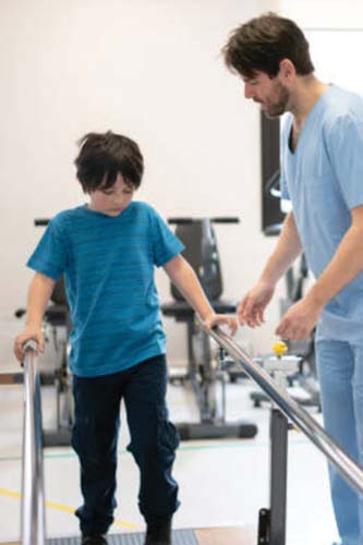 Boy walking using rail supports