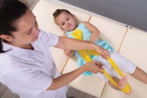 Young girl receiving resistance therapy on her leg